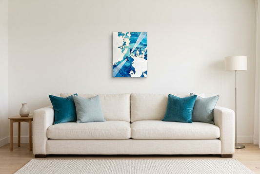 Underneath The Surface in a clean lounge with a creamy-white sofa and blue accent pillows
